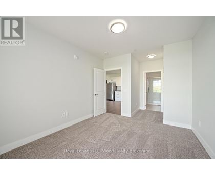 A large, empty room with a carpeted floor and white walls.