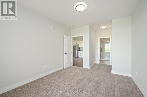 A large, empty room with a carpeted floor and white walls.