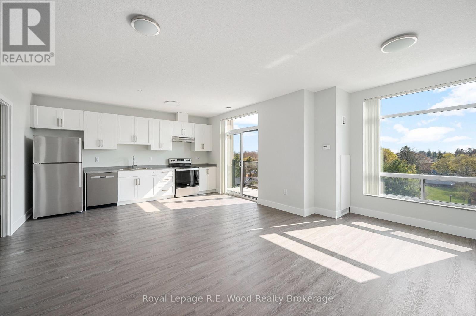 A spacious kitchen with white cabinets and a refrigerator.