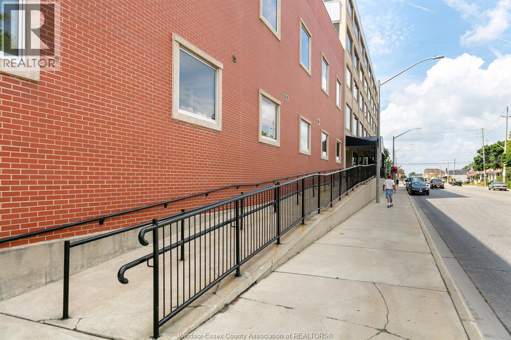 A red brick building with a black railing on the sidewalk.