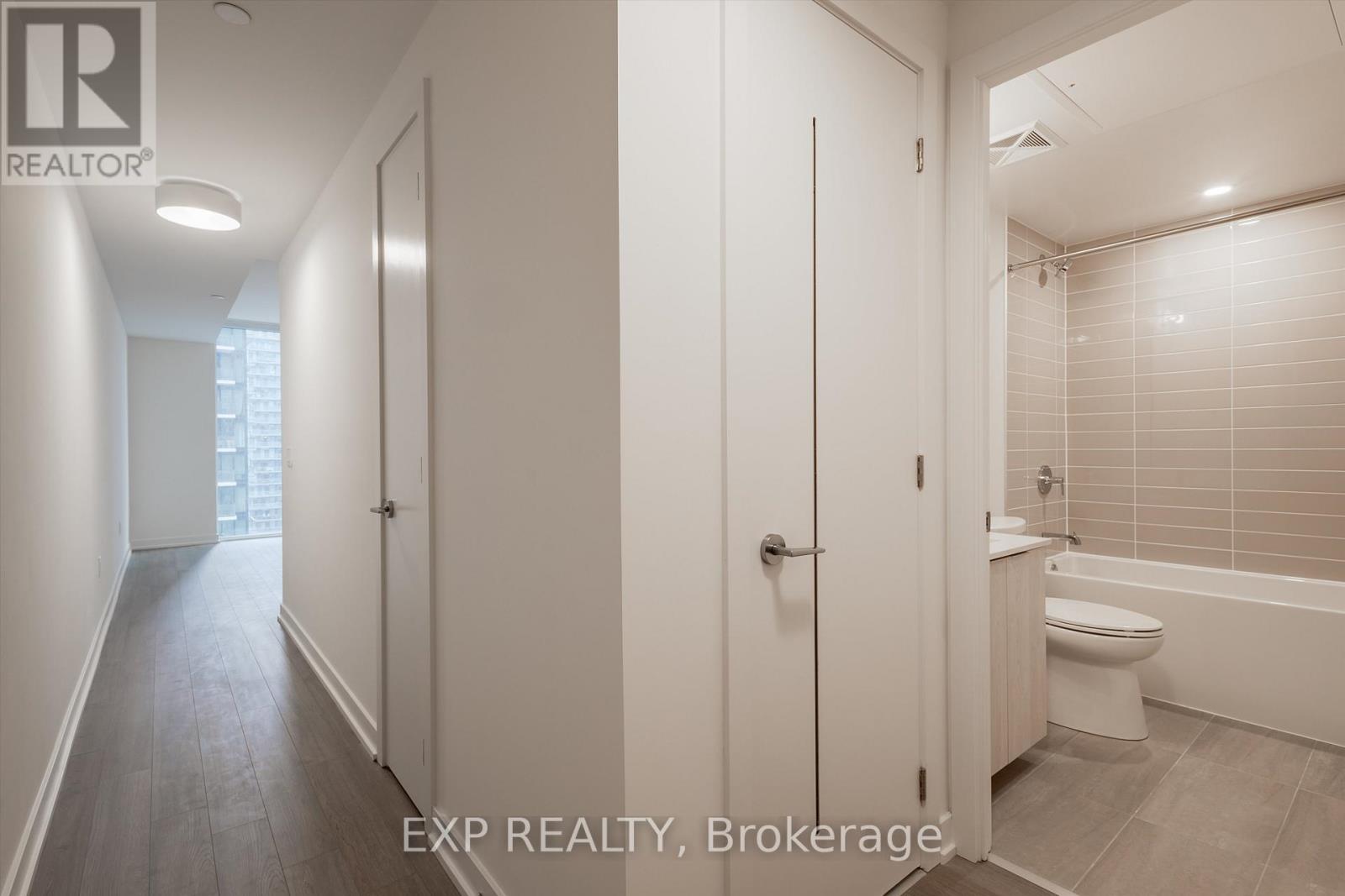 A white bathroom with a toilet, sink, and bathtub.
