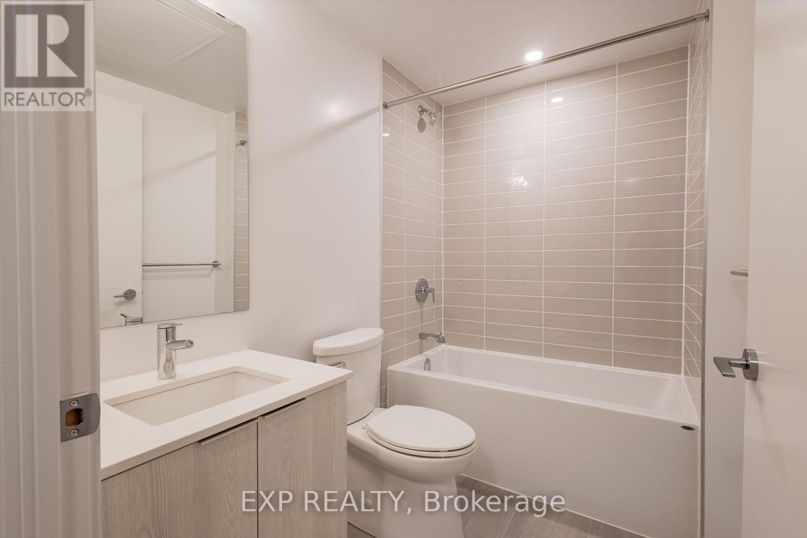 A white bathroom with a toilet, sink, and bathtub.