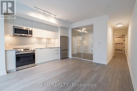 A kitchen with white cabinets and a stainless steel refrigerator.