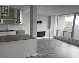 A modern kitchen with a large island and a flat screen TV mounted on the wall.