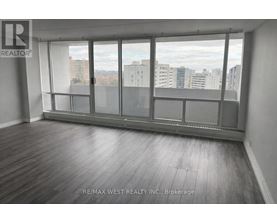 A room with a large window and wooden flooring.