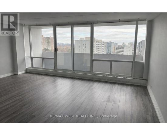 A room with a large window and wooden flooring.