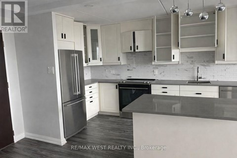 A kitchen with white cabinets and a black dishwasher.