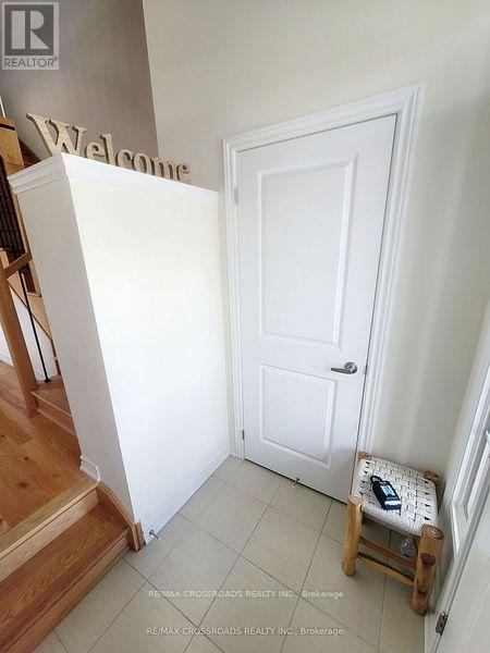A white door is in a hallway with a wooden staircase on the left.