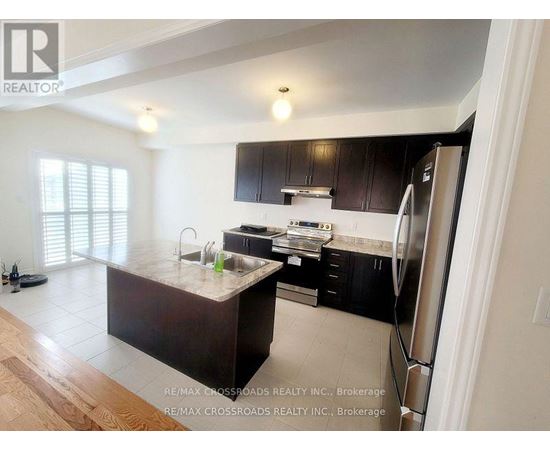 A kitchen with a refrigerator on the right side.