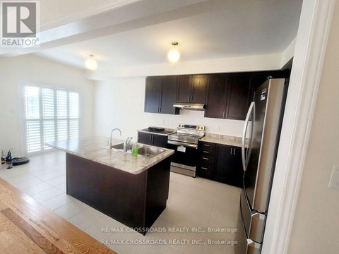 A kitchen with a refrigerator on the right side.