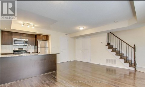 A spacious living room with a staircase leading to the upper floor.