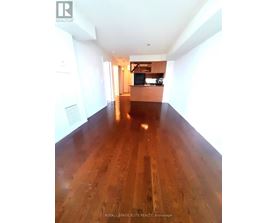 A long hallway with wood floors and white walls.