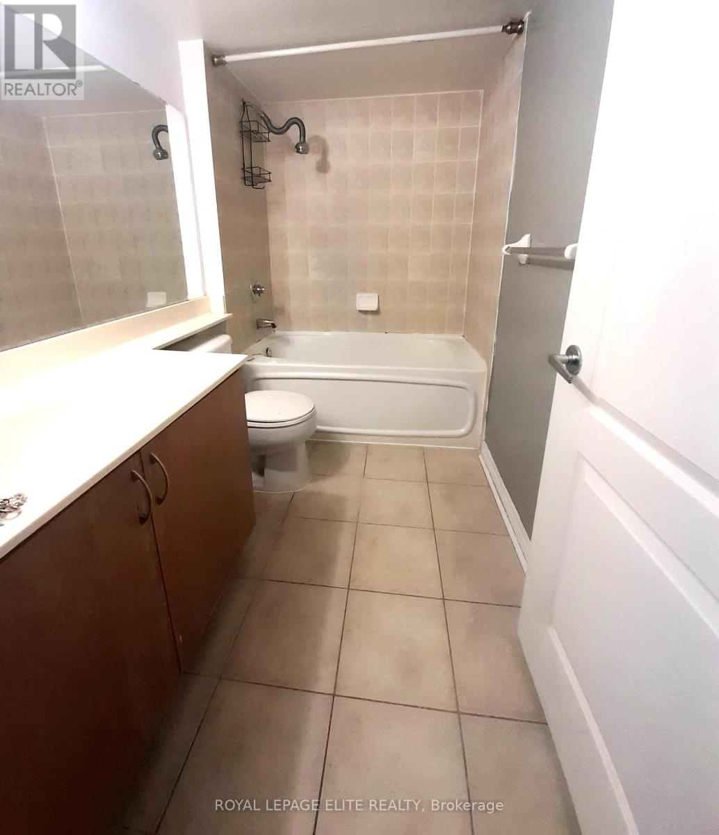 A white bathtub is in a bathroom with white walls and a white toilet.