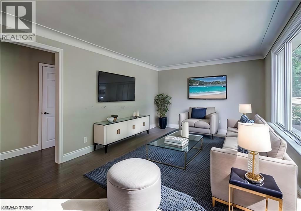 A living room with a white couch, a glass coffee table, and a painting on the wall.