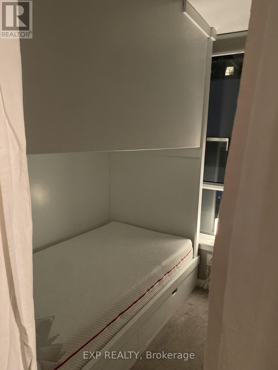 A small bedroom with a bed and a shelf in the background.