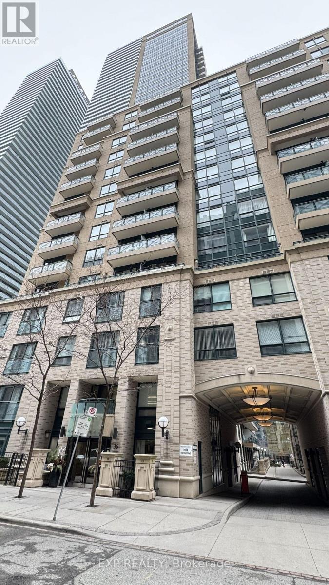 A tall building with a glass facade stands behind a smaller building with a stone facade.