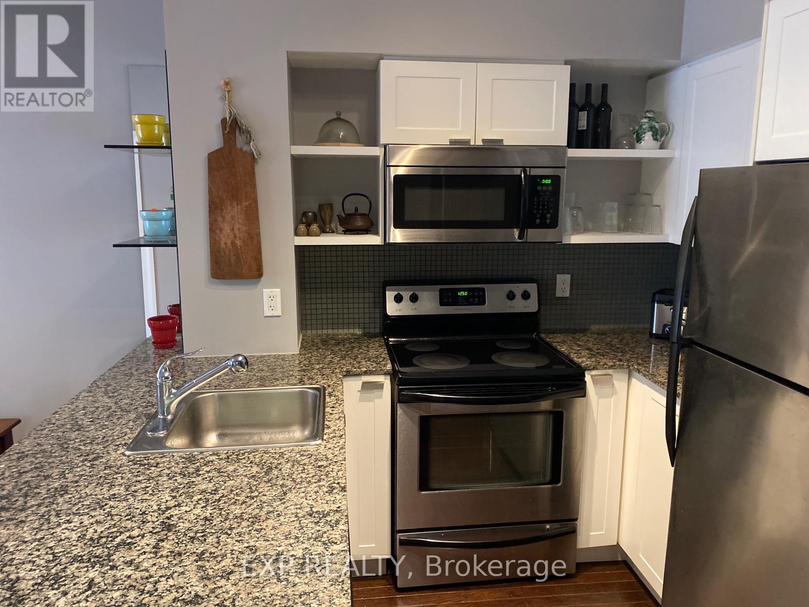 A kitchen with a stove top oven, microwave, and refrigerator.