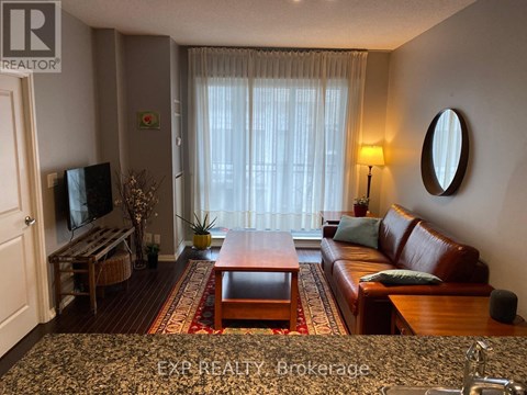 A living room with a brown leather couch and a wooden coffee table.