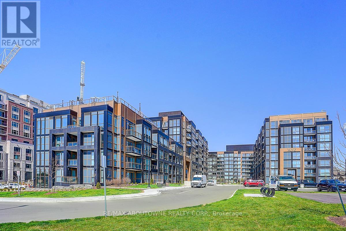 A row of modern apartment buildings with cars parked in front.