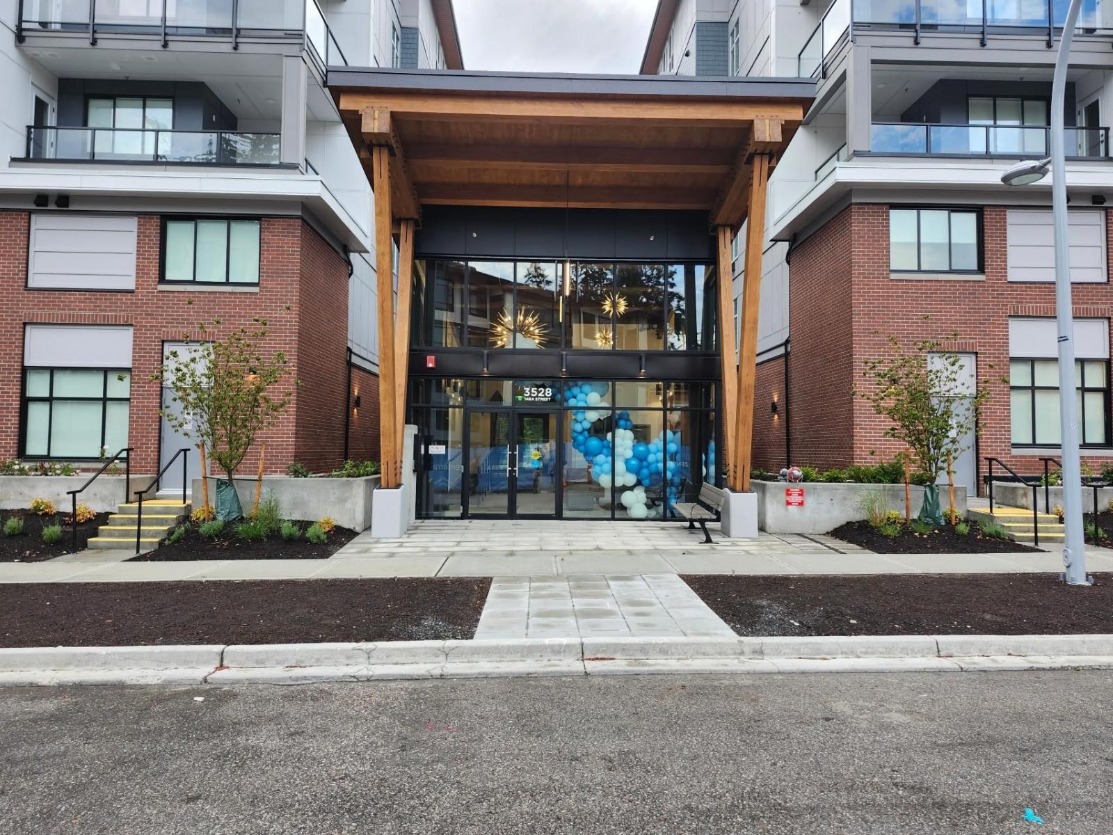 A modern building with a glass entrance and brick walls.