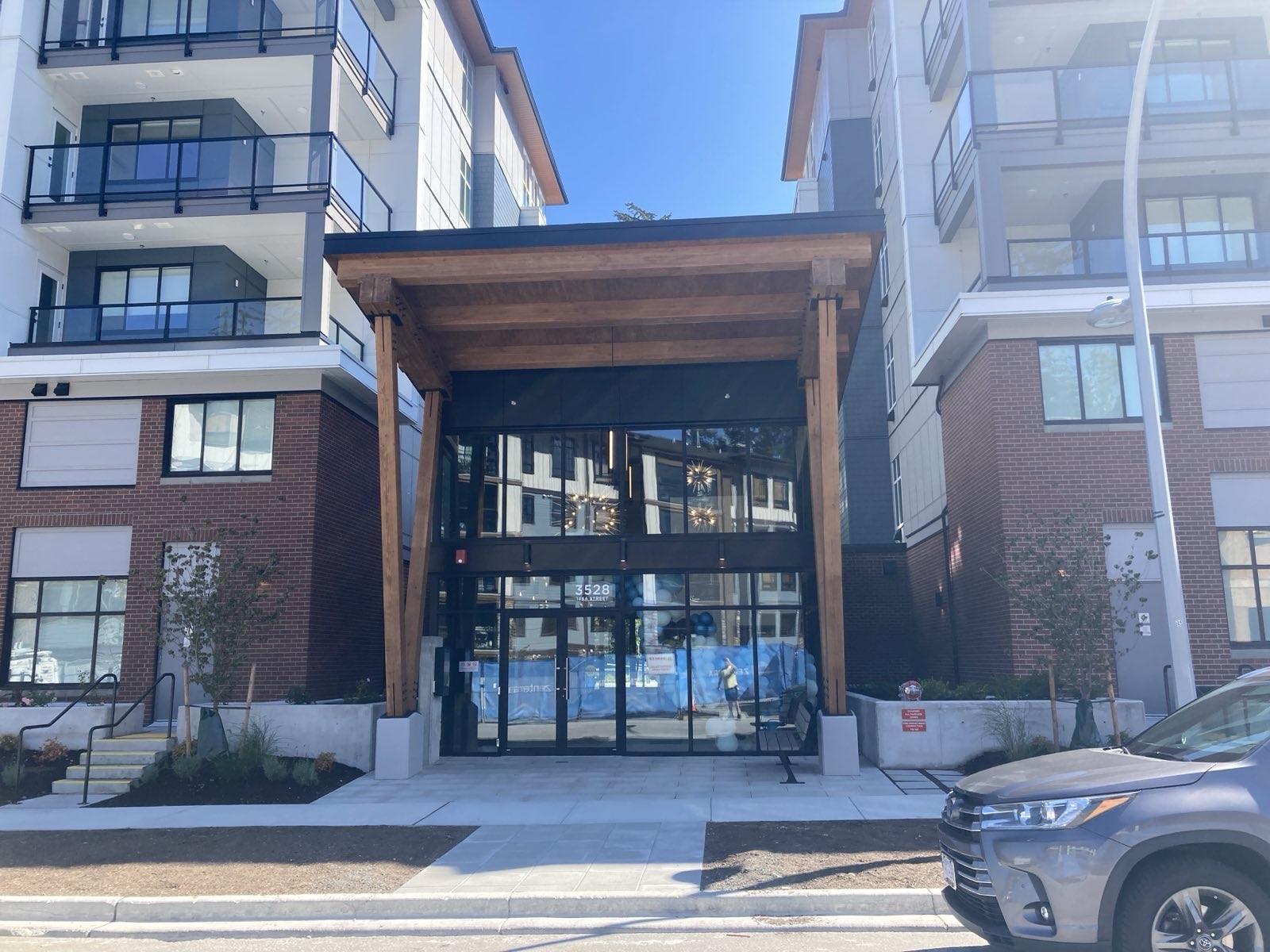 A modern building with a wooden entrance and a car parked in front.