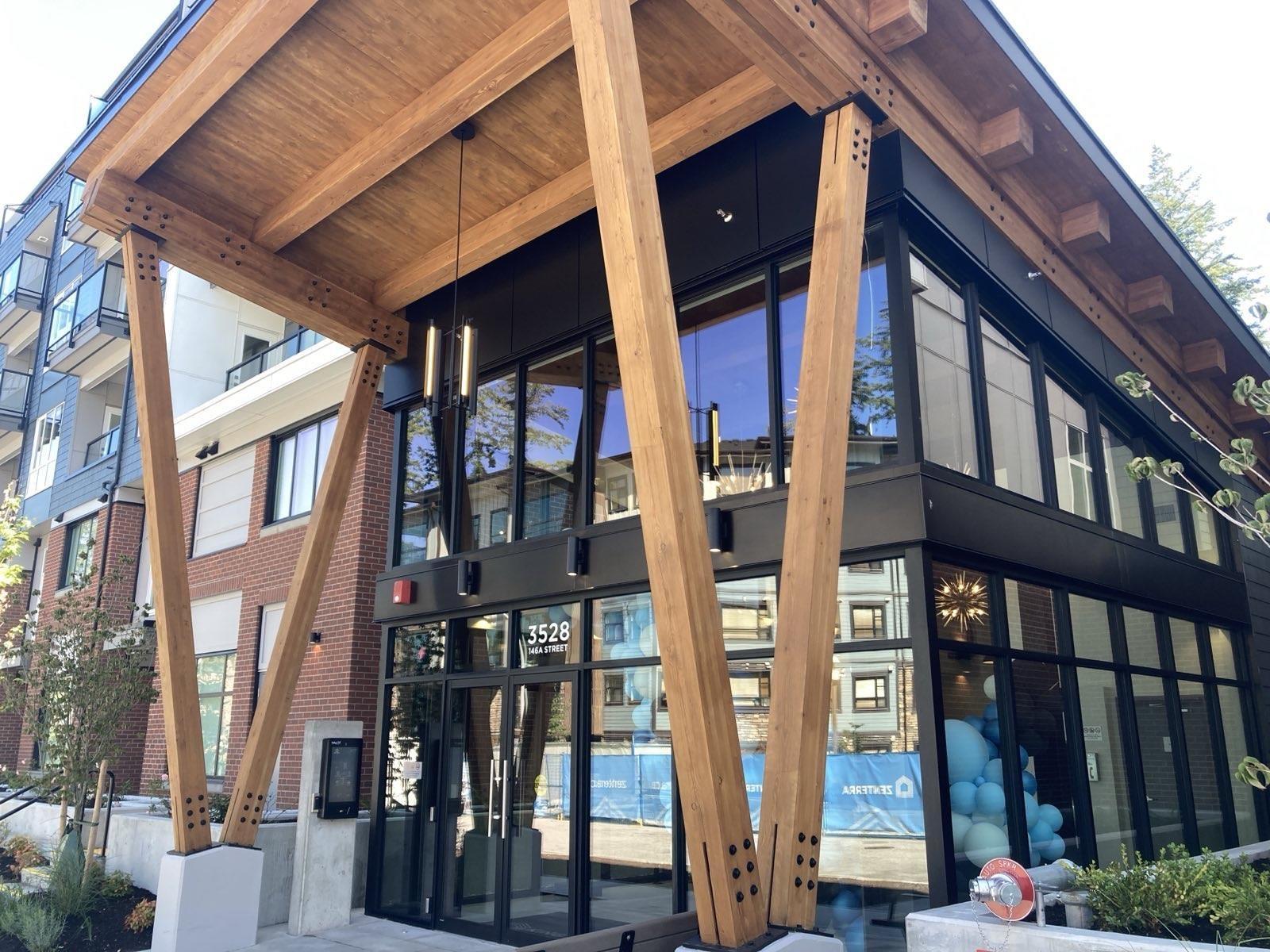 A modern building with a wooden roof and glass windows.