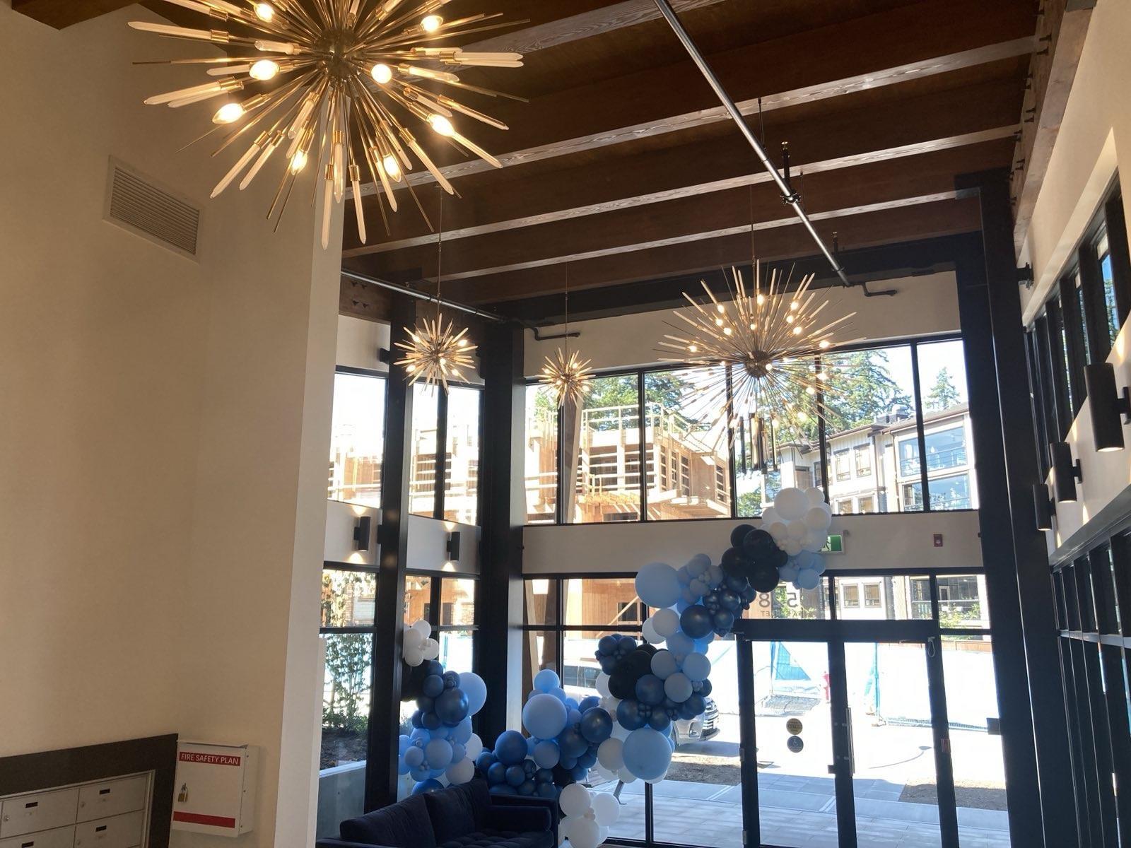 A large chandelier hangs from the ceiling in a room with a view of the outside.