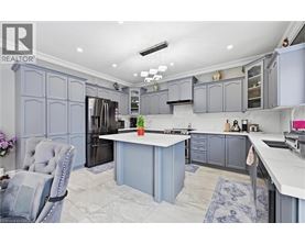 A kitchen with a grey chair and a white counter.