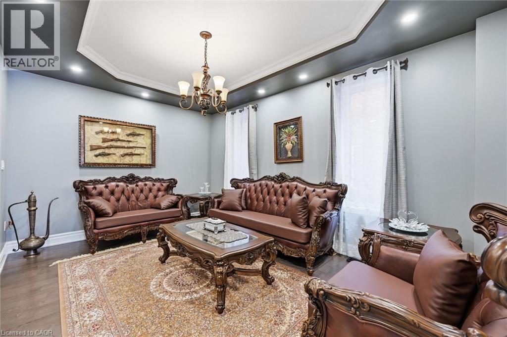 A living room with brown leather furniture and a chandelier.