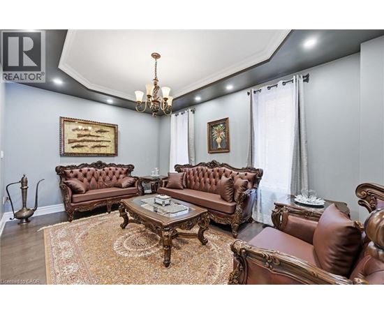 A living room with brown leather furniture and a chandelier.