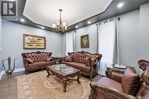 A living room with brown leather furniture and a chandelier.
