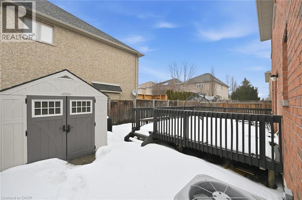 A snow-covered ground with a wooden fence and a building in the background.