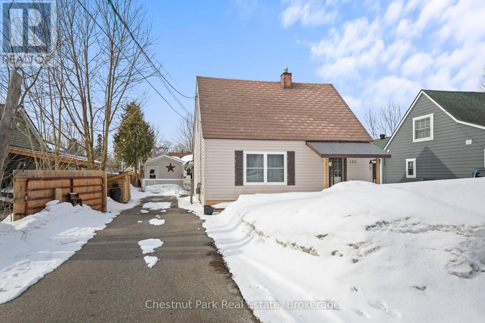 A house with a brown roof is surrounded by snow.