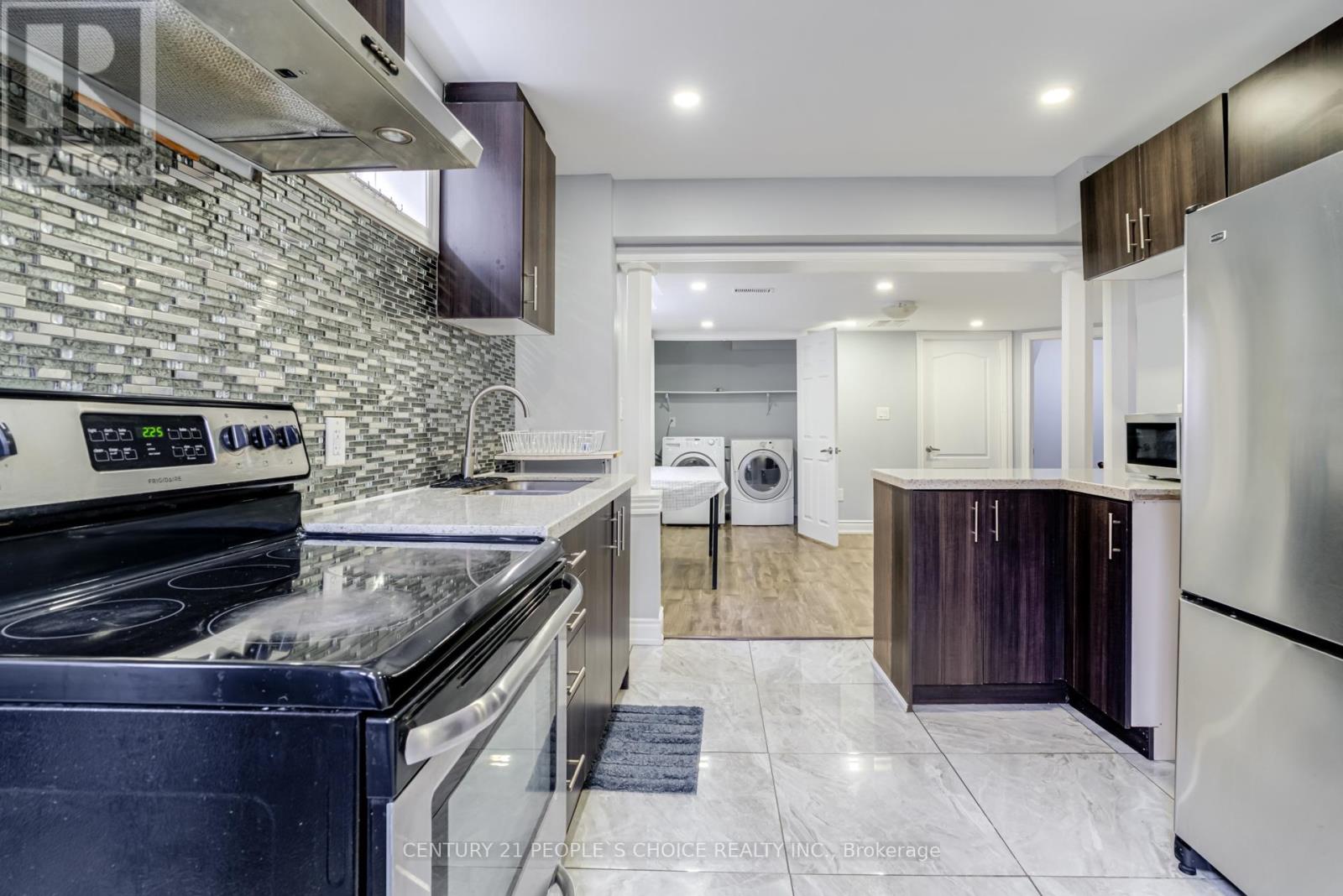 A modern kitchen with a stove top oven and a refrigerator.