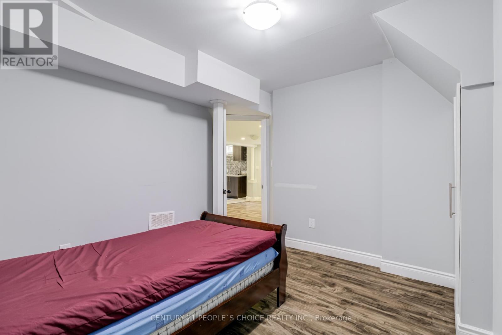Bedroom with a bed and a doorway leading to another room.