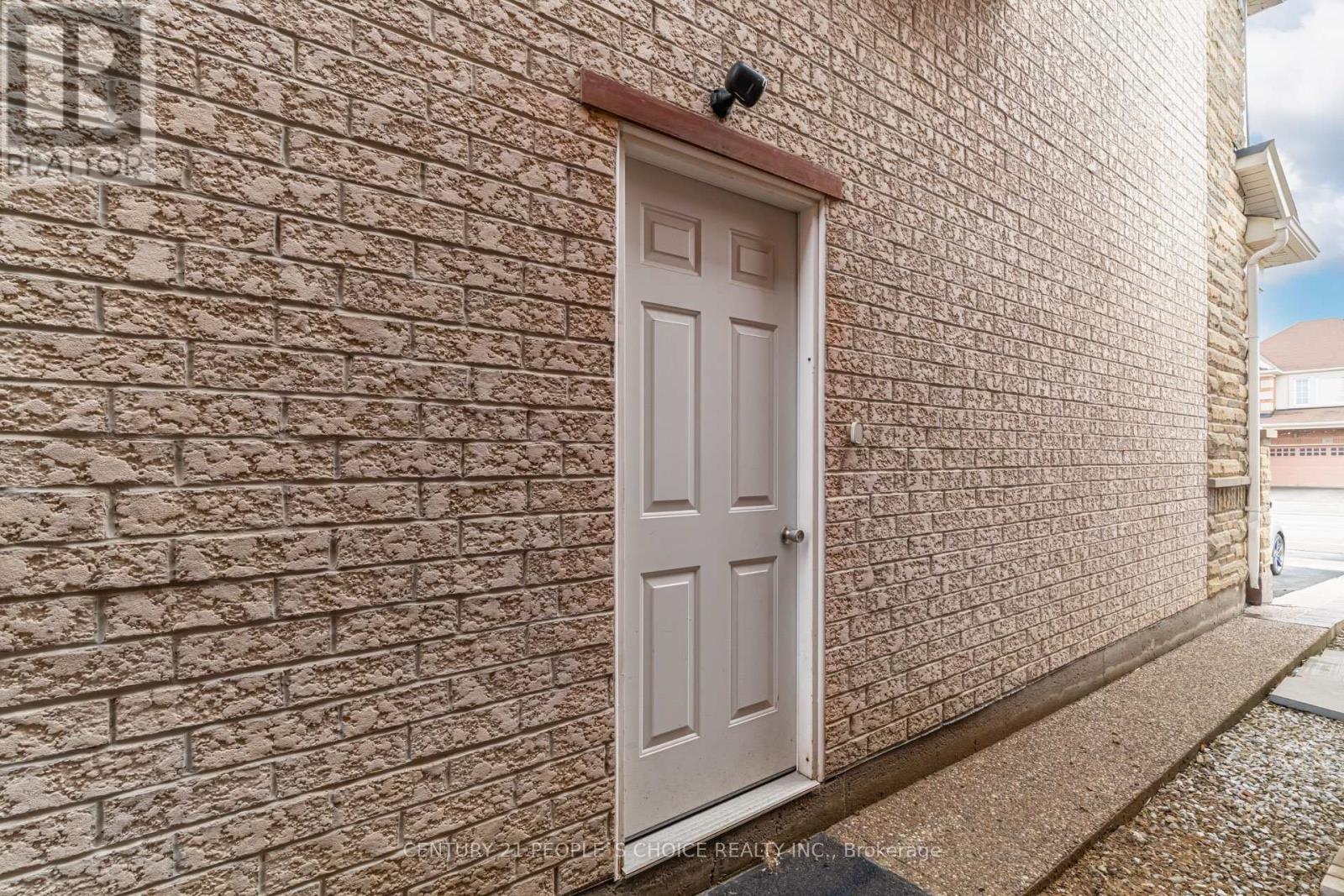 A white door is on a brick wall.