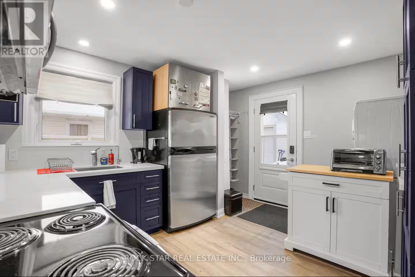 A kitchen with a stove top oven and a refrigerator.