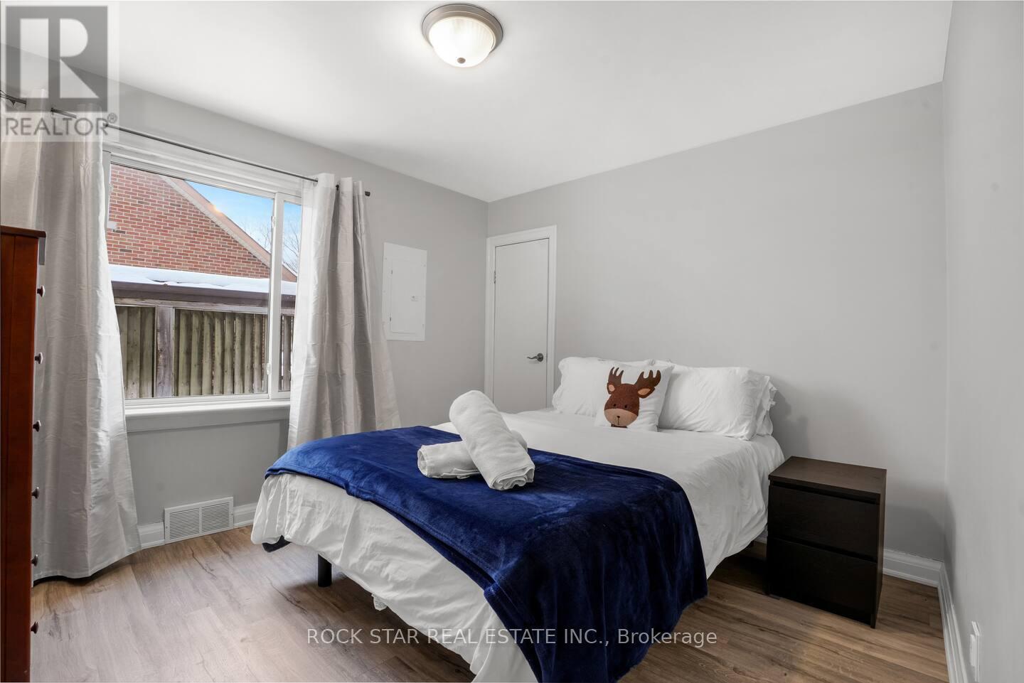 A bedroom with a bed covered in a blue blanket and a deer head on the pillow.