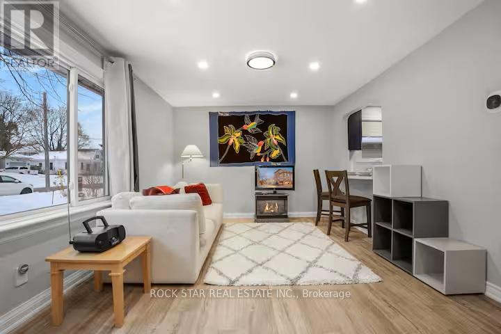 A living room with a white couch, a wooden table, and a painting on the wall.