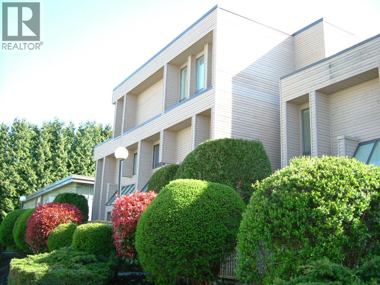 A modern house with a well-manicured garden in front.