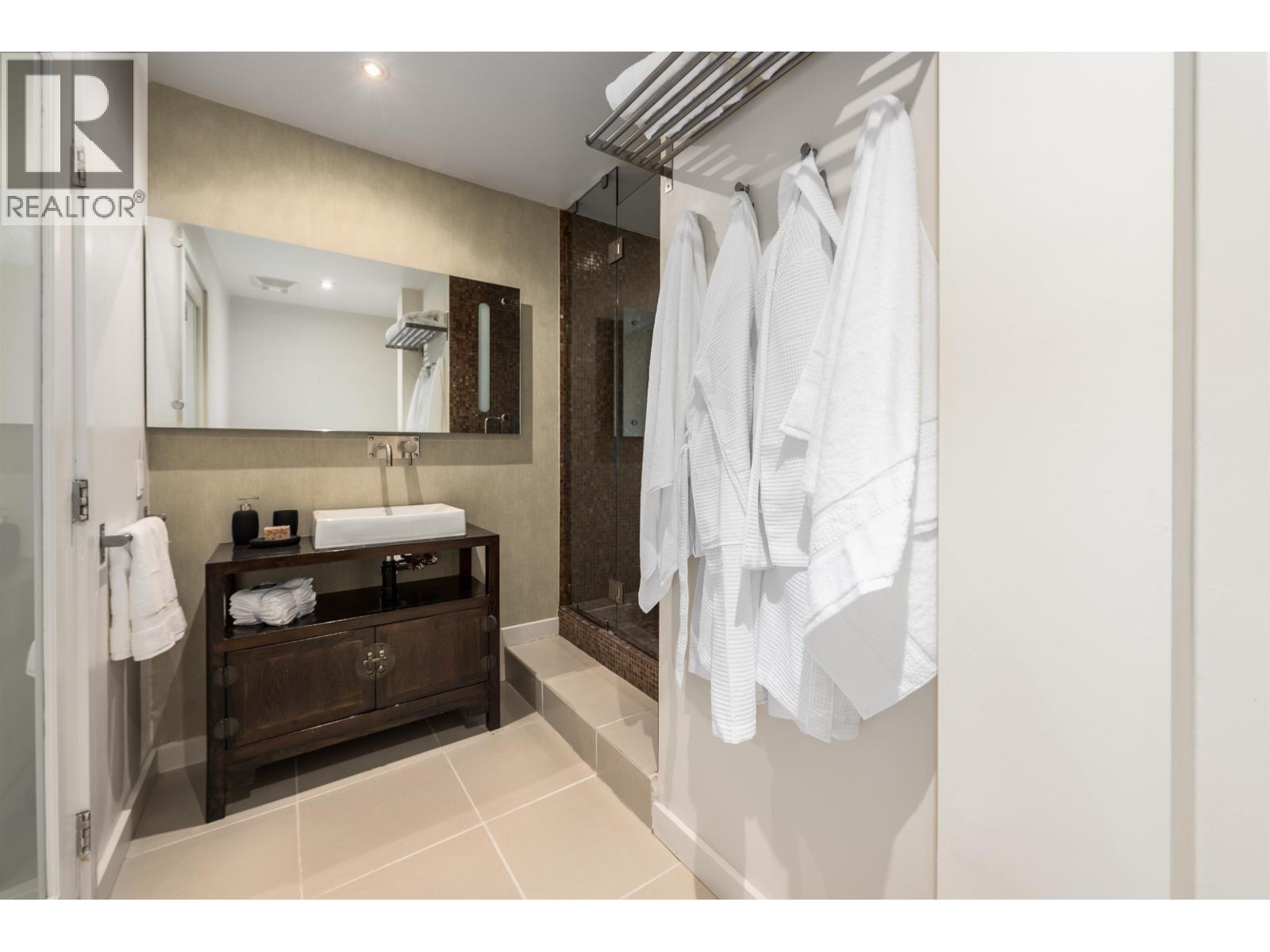 A bathroom with a sink, mirror, and towel rack.
