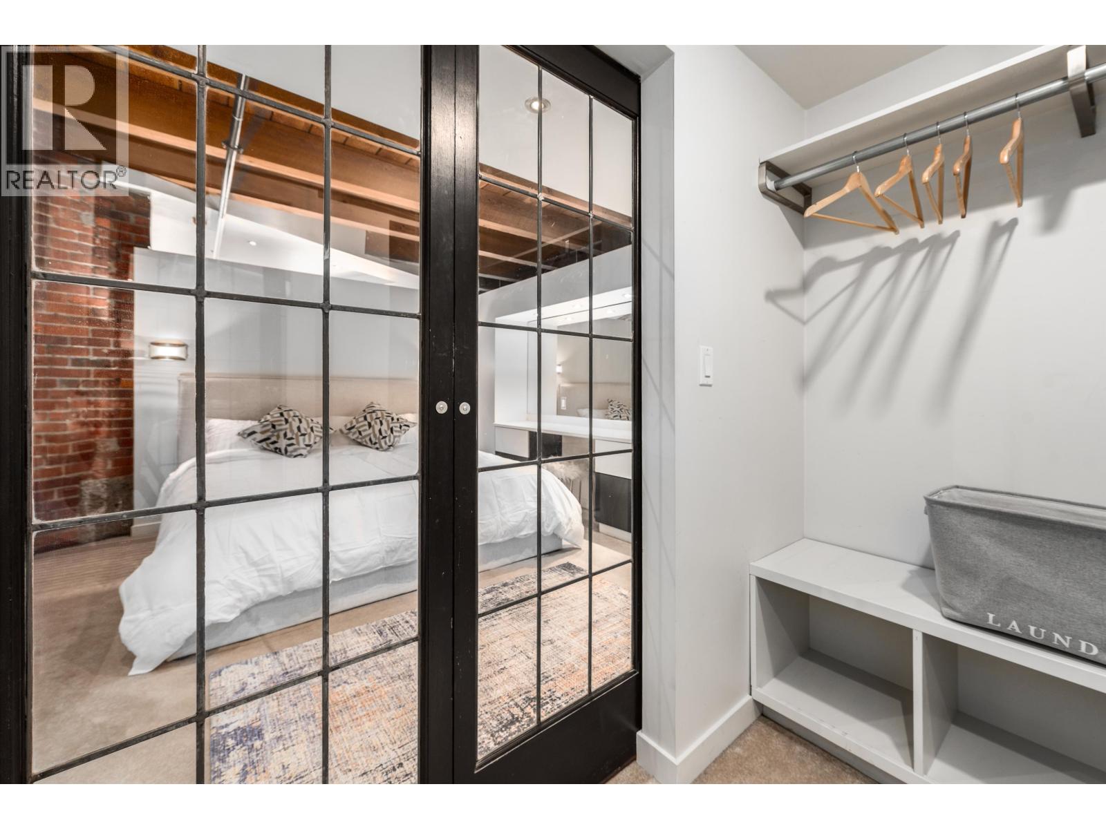 A bedroom with a bed and a laundry basket.