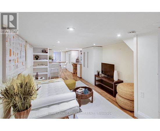A well-lit, modern living room with a white sofa and a television.