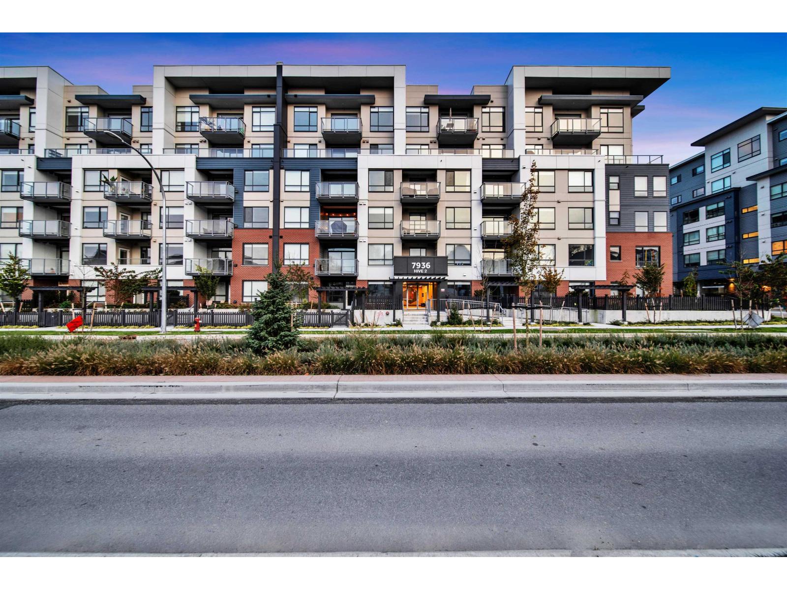 Apartment buildings with balconies line a street.