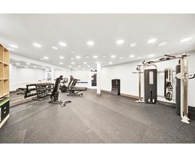 A gym with a variety of equipment including treadmills, weights, and exercise machines.