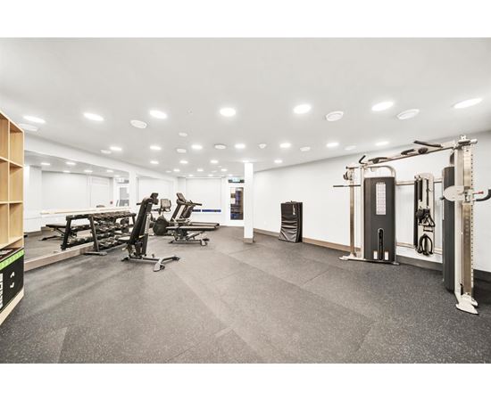 A gym with a variety of equipment including treadmills, weights, and exercise machines.