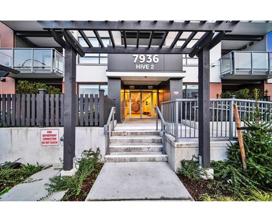The front entrance to a building with a sign that reads 7936 HIVE 2.
