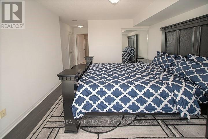 A bedroom with a bed covered in a blue and white patterned bedspread.