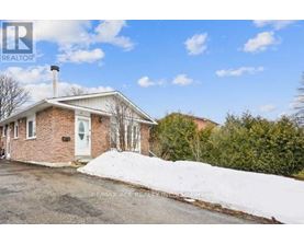 A house with a white door and a chimney is surrounded by snow.