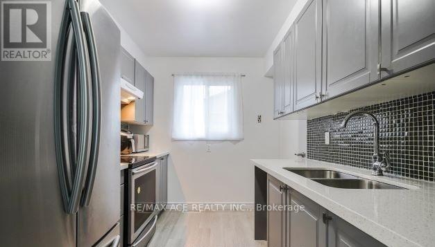A kitchen with a stainless steel refrigerator and a sink with a faucet.